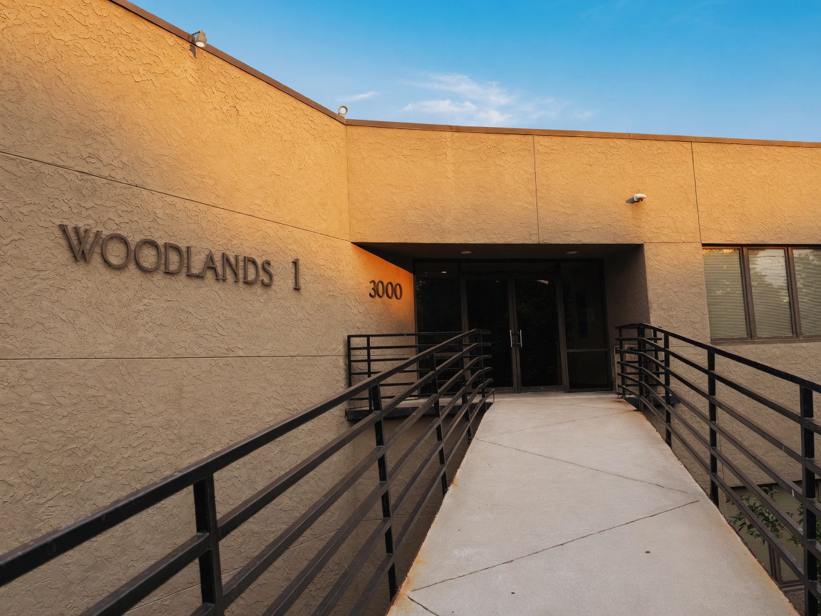 Main entrance ramp and WOODLANDS 1 lettering at sunset